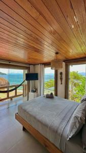 um quarto com uma cama grande e vista para o oceano em Pousada Belas Águas em Praia de Araçatiba