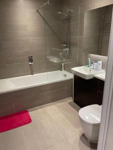 a bathroom with a tub and a toilet and a sink at Laurel Point in London