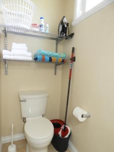 a bathroom with a toilet and a mop and towels at Keep Cool Guesthouse in Gros Islet