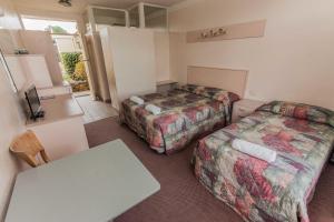 a hotel room with two beds and a television at Moruya Waterfront Hotel Motel in Moruya