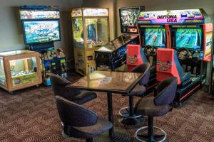 un mucchio di videogiochi in una stanza con sedie di Moruya Waterfront Hotel Motel a Moruya