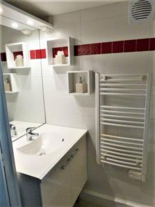 ein weißes Badezimmer mit einem Waschbecken und einem Spiegel in der Unterkunft Appartement de 2 chambres avec sauna terrasse et wifi a Latresne in Latresne