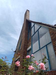 una ventana en una casa de ladrillo con rosas rosas en Encantadora Finca San Gabriel Duitama, en Duitama