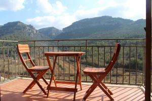 2 sillas y una mesa en un balcón con montañas en 2 bedrooms appartement with terrace and wifi at Capafonts, en Capafons