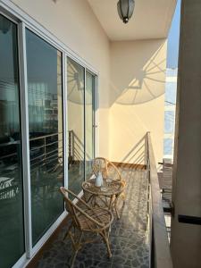 a patio with a table and chairs on a balcony at Willow Pillow Guest House & Poshtel in Chumphon