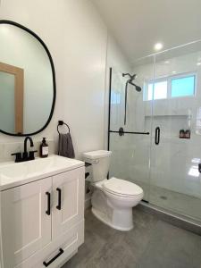 a bathroom with a toilet and a shower with a mirror at Modern Two Bedroom Two Bath W/ Parking and Laundry in Los Angeles