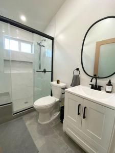 y baño con aseo, lavabo y espejo. en Modern Two Bedroom Two Bath W/ Parking and Laundry, en Los Ángeles