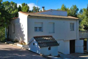 - un bâtiment blanc avec une petite maison à côté dans l'établissement 3 bedrooms chalet with private pool terrace and wifi at Valencia, à Torrent