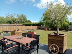 een tafel en stoelen en een boom in een tuin bij Chalet de 3 chambres avec terrasse et wifi a Marck a 1 km de la plage in Marck