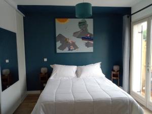 1 dormitorio con 1 cama grande y pared azul en Chalet de 3 chambres avec terrasse et wifi a Marck a 1 km de la plage, en Marck