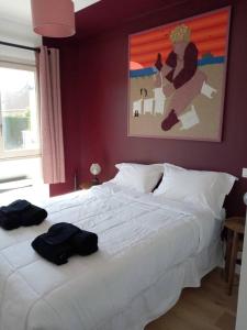 una camera da letto con un letto bianco e un dipinto sul muro di Chalet de 3 chambres avec terrasse et wifi a Marck a 1 km de la plage a Marck