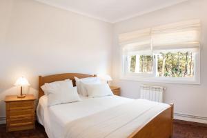 um quarto com uma grande cama branca e uma janela em 5 bedrooms chalet with private pool and wifi at Sao Pedro do Sul em São Pedro do Sul
