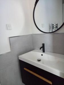 bagno con lavandino bianco e specchio di Chalet de 3 chambres avec terrasse et wifi a Marck a 1 km de la plage a Marck