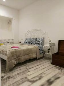 um quarto branco com uma cama com almofadas de zebra em One bedroom appartement with terrace and wifi at Finocchito em Finocchito