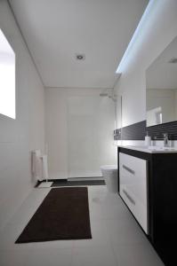 a white bathroom with a sink and a toilet at 3 bedrooms chalet with private pool and wifi at Varzea in Várzea