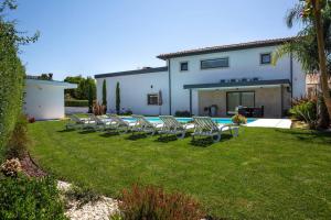 a row of lawn chairs in a yard with a pool at 3 bedrooms chalet with private pool and wifi at Varzea in Várzea