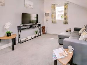 a living room with a couch and a flat screen tv at 1 Bed in Holmfirth 88554 in Holmfirth