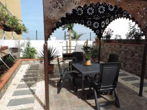 a table and chairs under an umbrella on a patio at One bedroom appartement with wifi at San Cristobal de La Laguna 3 km away from the beach in Las Lagunas