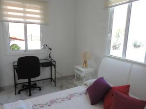 a bedroom with a bed and a desk and windows at One bedroom appartement with wifi at San Cristobal de La Laguna 3 km away from the beach in Las Lagunas