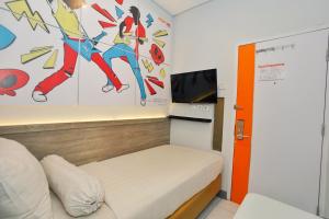 a small room with a bed and a tv at Front One Cabin Setiabudi Solo in Solo