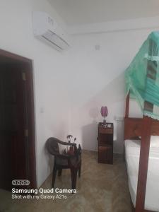 a room with a bedroom with a chair and a desk at Eura Villa in Bentota