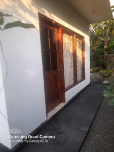 a house with a wooden door and a porch at Eura Villa in Bentota