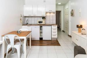 cocina con armarios blancos y mesa con microondas en One bedroom appartement at Corralejo 200 m away from the beach with wifi, en Corralejo