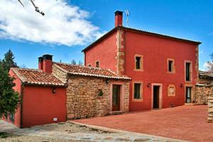 un grande edificio in mattoni rossi con garage rosso di 5 bedrooms house with terrace and wifi at Aldehuela Sepulveda a Hinojosas del Cerro