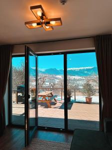 Sohodol的住宿－Zenit Chalet Sohodol-Bran，客厅配有吊扇和滑动玻璃门。