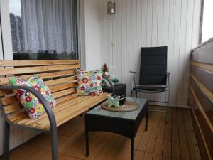 a bench with pillows and a chair in a room at FeWo Glücksmoment in Idar-Oberstein