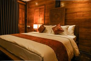 MungguにあるTegal Campuhan Retreatsの木製の壁のベッドルーム1室(大型ベッド1台付)