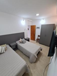 a bedroom with two beds and a flat screen tv at Tres Marías Apart in Chilecito