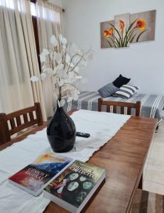 a table with magazines and a vase on top of it at Tres Marías Apart in Chilecito