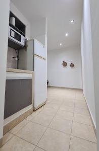 a kitchen with a refrigerator and a tile floor at Tres Marías Apart in Chilecito