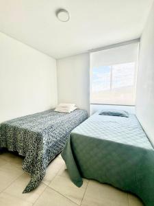 1 dormitorio con 2 camas y ventana en Apartamento Ibagué Mirador De Los Andes Mirolindo, en Ibagué