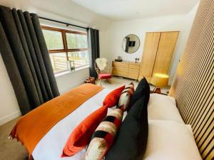 a bedroom with a bed with pillows and a window at Stags Hide - Aviemore 