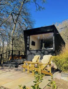 a couple of chairs and a bench in front of a building at The Roost, Scotland in Aviemore