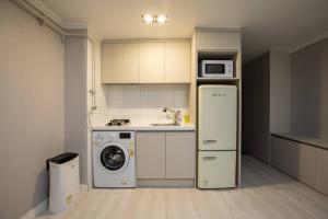 a kitchen with a washing machine and a microwave at Special House in Seoul