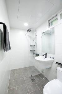 a white bathroom with a sink and a toilet at Special House in Seoul