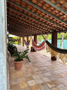 a patio with hammocks hanging from a wooden roof at Pousada Recanto das Orquídeas in Barreirinhas