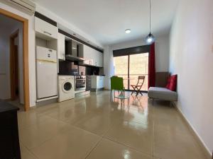 a kitchen and living room with a couch and a chair at Estancias mensuales Terrassa in Terrassa