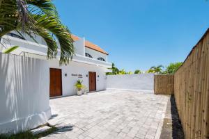 a white house with a fence and a driveway at Beach Villas Canggu 300m from Echo Beach in Canggu