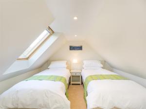 two beds in a attic room with a window at 6 Bed in Applecross CA343 in Applecross