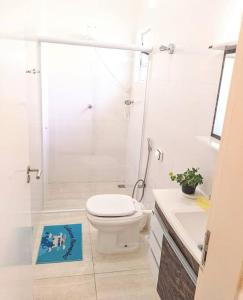 une salle de bain blanche avec toilettes et douche dans l'établissement Island House : Sua Casa na Ilha!, à Ilha Comprida 13 autres photos