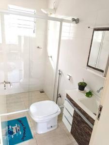 une salle de bain blanche avec toilettes et lavabo dans l'établissement Island House : Sua Casa na Ilha!, à Ilha Comprida