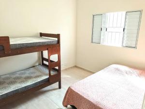 une chambre avec deux lits superposés et une fenêtre dans l'établissement Island House : Sua Casa na Ilha!, à Ilha Comprida