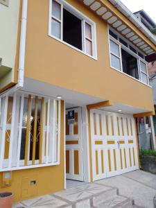 una casa amarilla con una puerta de garaje blanca en Hostal Kuyay en Filandia