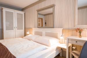 1 dormitorio con 1 cama blanca grande y espejo en Hotel Maxant, en Frymburk