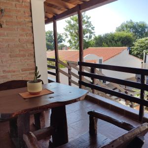 - une table en bois sur une terrasse couverte avec une plante en pot dans l'établissement Luna de Cuarzo, à Cafayate