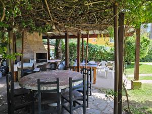 een patio met een tafel en stoelen en een open haard bij Chalet Araceli in Pinamar